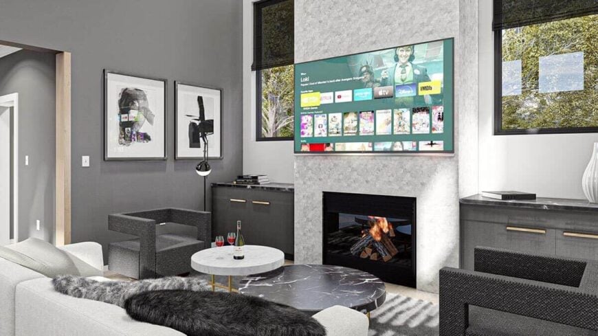 The great room features modern seats, nesting coffee tables, and a large TV fixed above the fireplace.