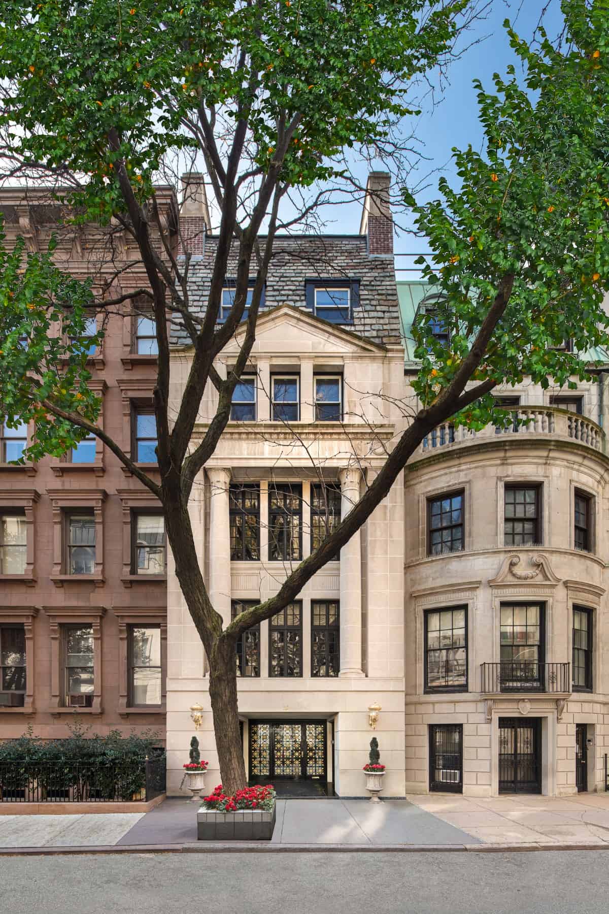 Home facade with beige brick cladding, a glazed front door, and huge windows.