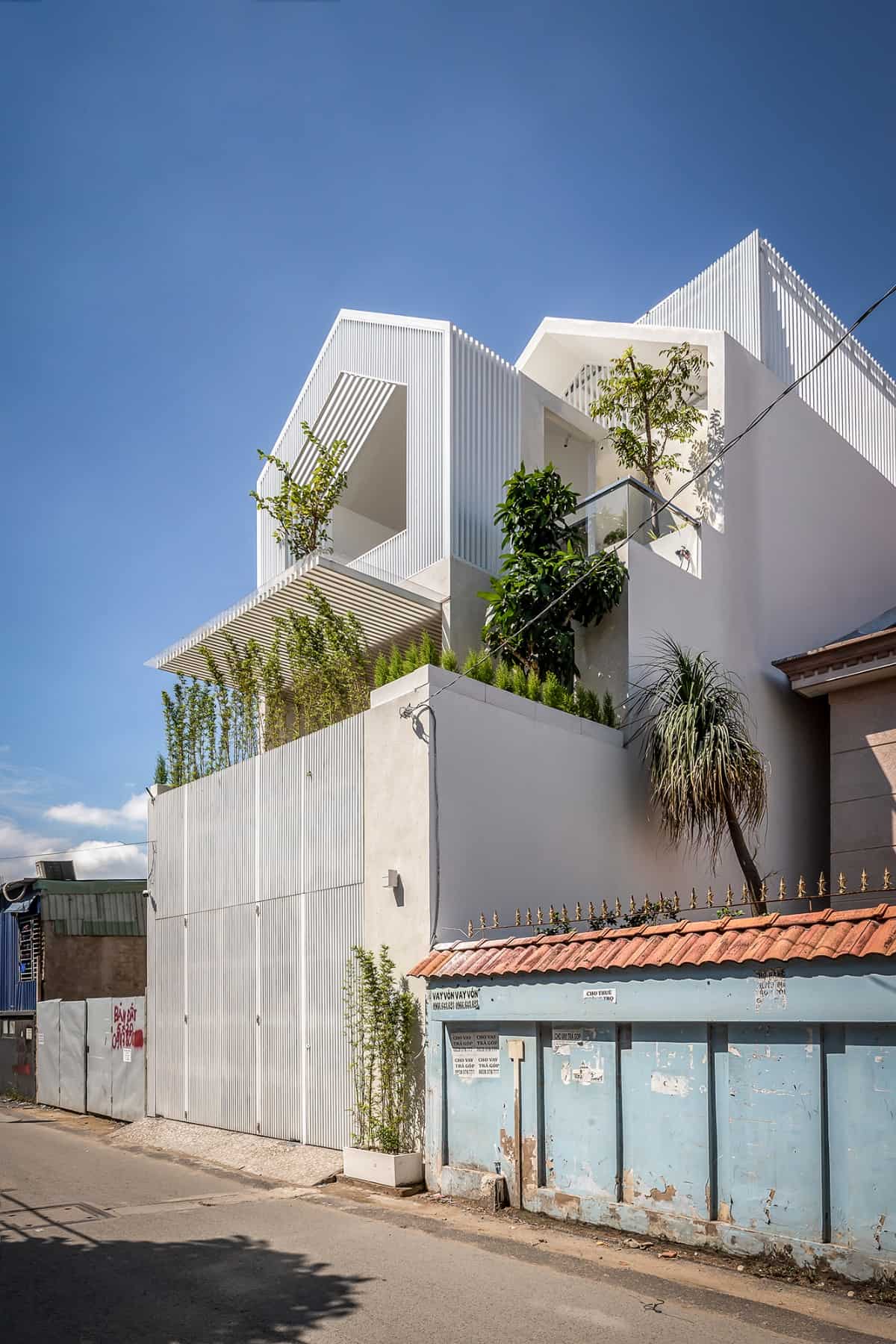 Fresh plants accentuate the home's stark white exterior.