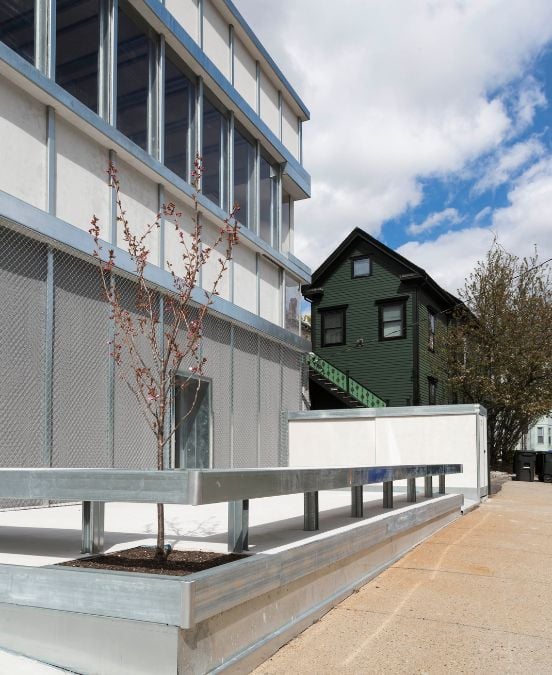 An enclosed small outdoor space located at the entrance of the building, constructed using prefabricated materials.