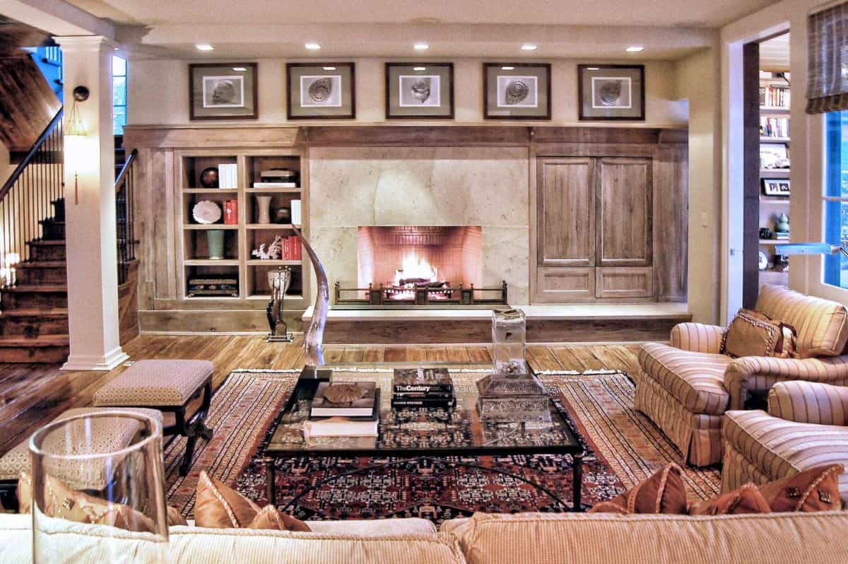 The living room features a marble fireplace flanked by a built-in cabinet and shelves.