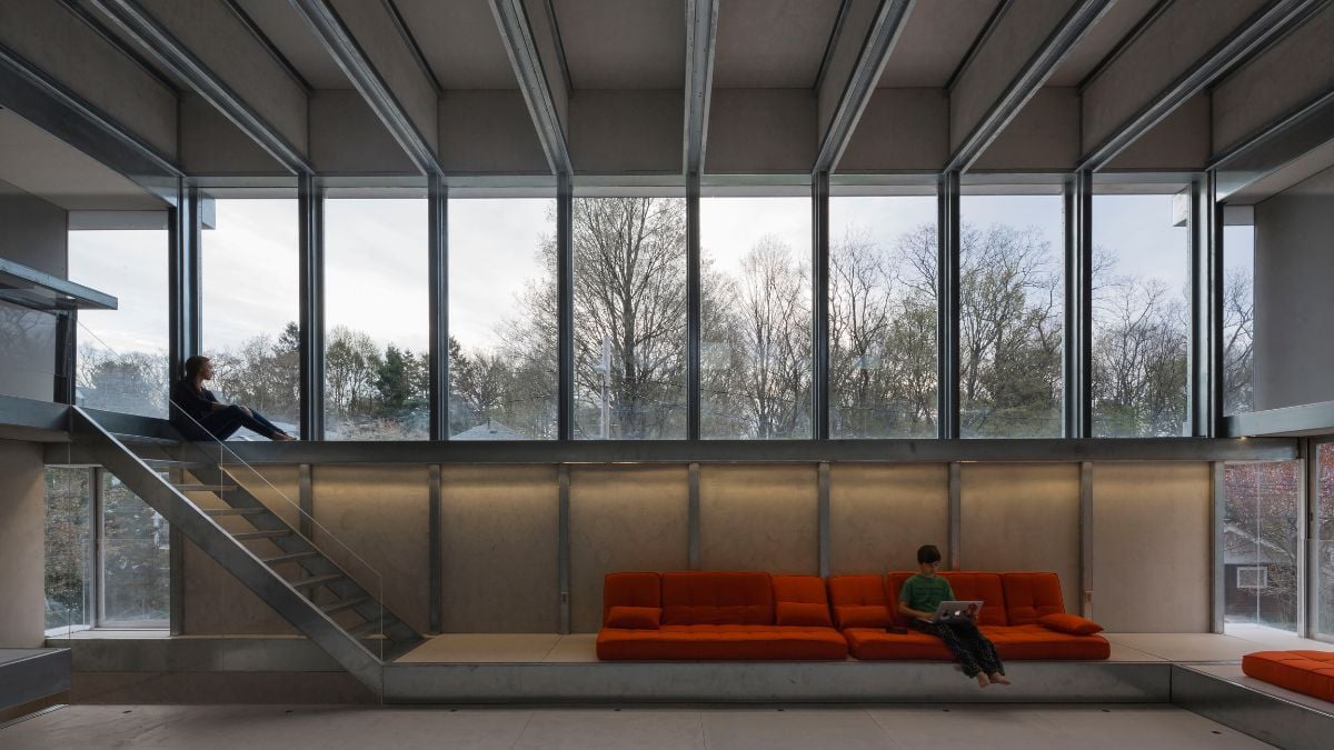 An interior shot of the unit showcasing the high ceiling and spacious layout, as well as the large glass window panels that allow natural light to flood in.