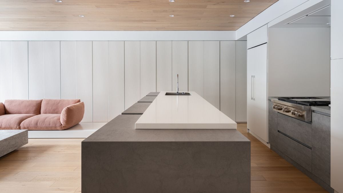 An interior view showcasing a shared living and kitchen space featuring a long rectangular island table.