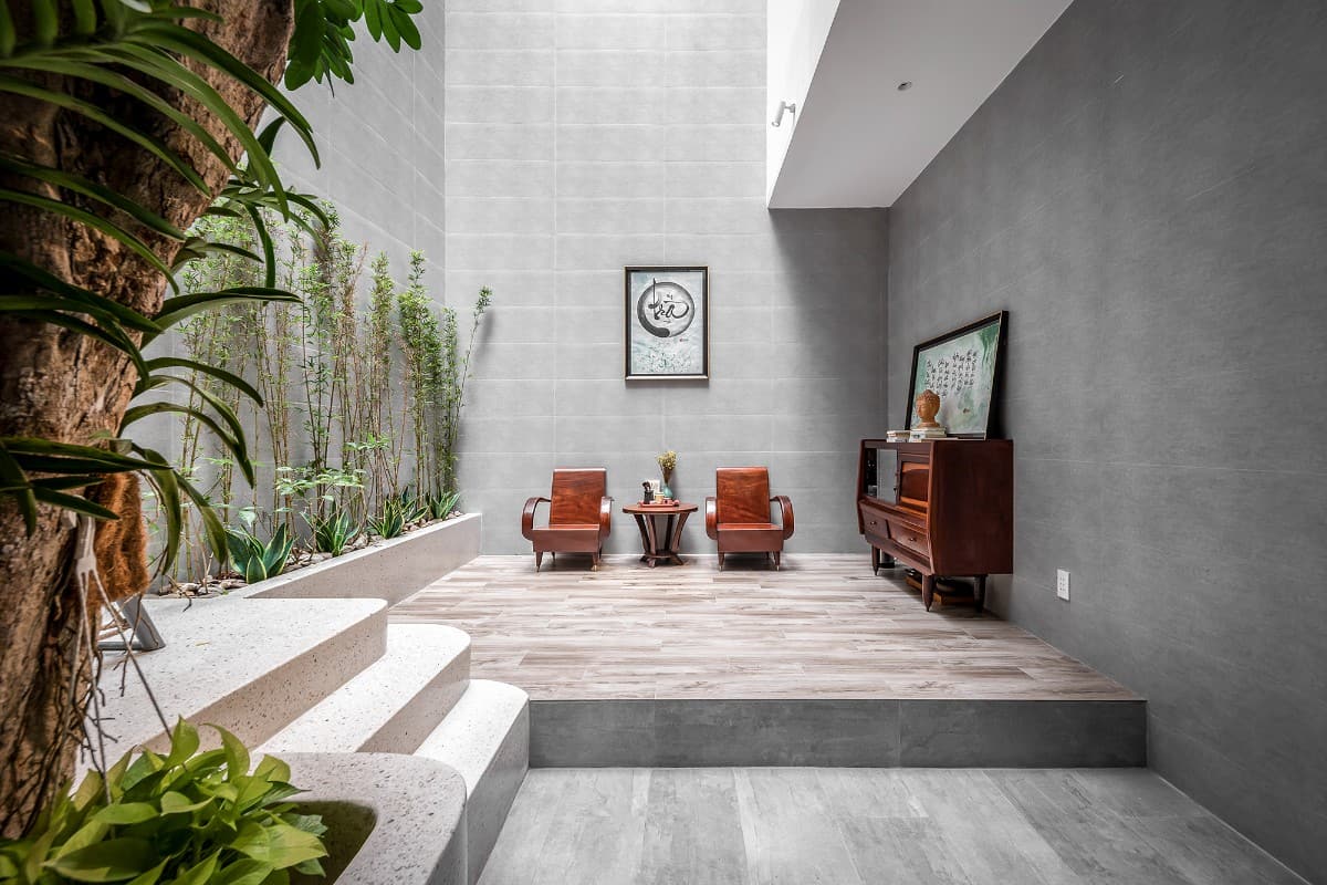Atrium with two seats and surrounding plants for added ambiance.