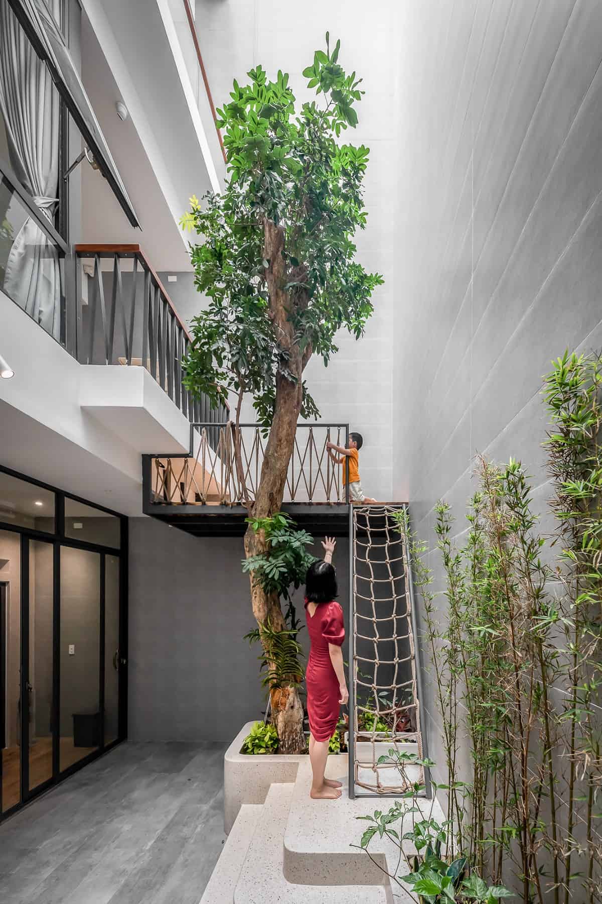 Kids can climb the loft adorned with a towering plant. This loft mimics a treehouse.