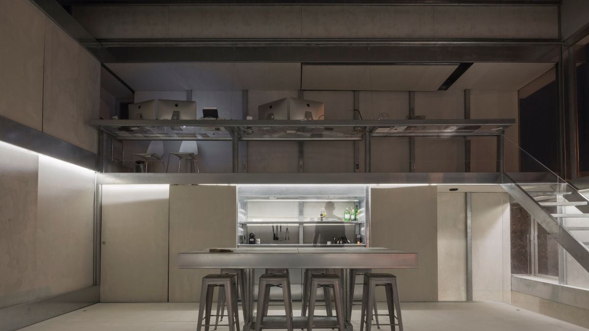 An interior shot featuring a detailed view of the loft office space and the kitchen area below, complete with a center island.
