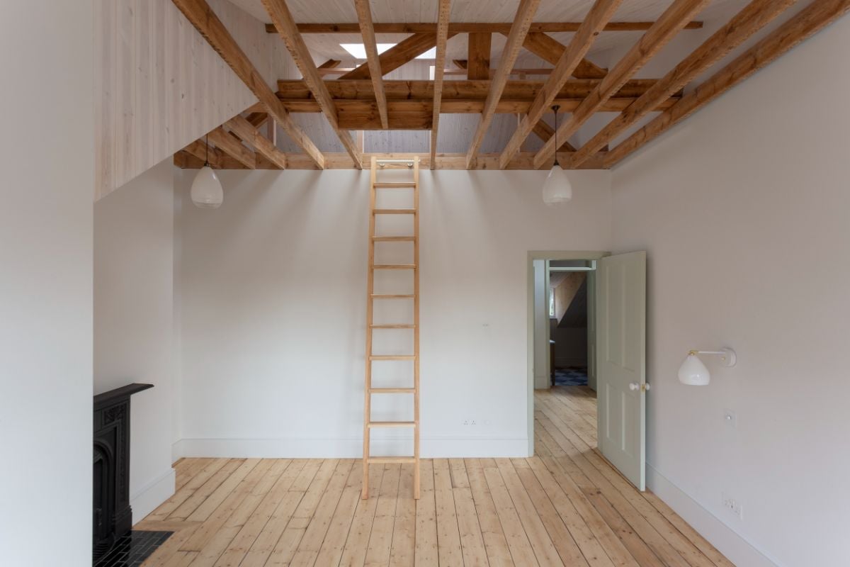 The rear bedroom features a wooden ladder that leads to the attic and a roof door.