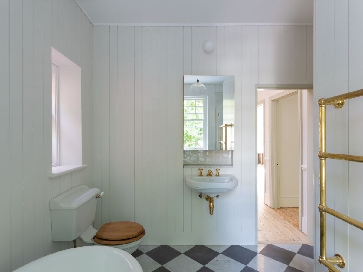 The family bathroom features a classic wooden toilet seat and a bathtub.