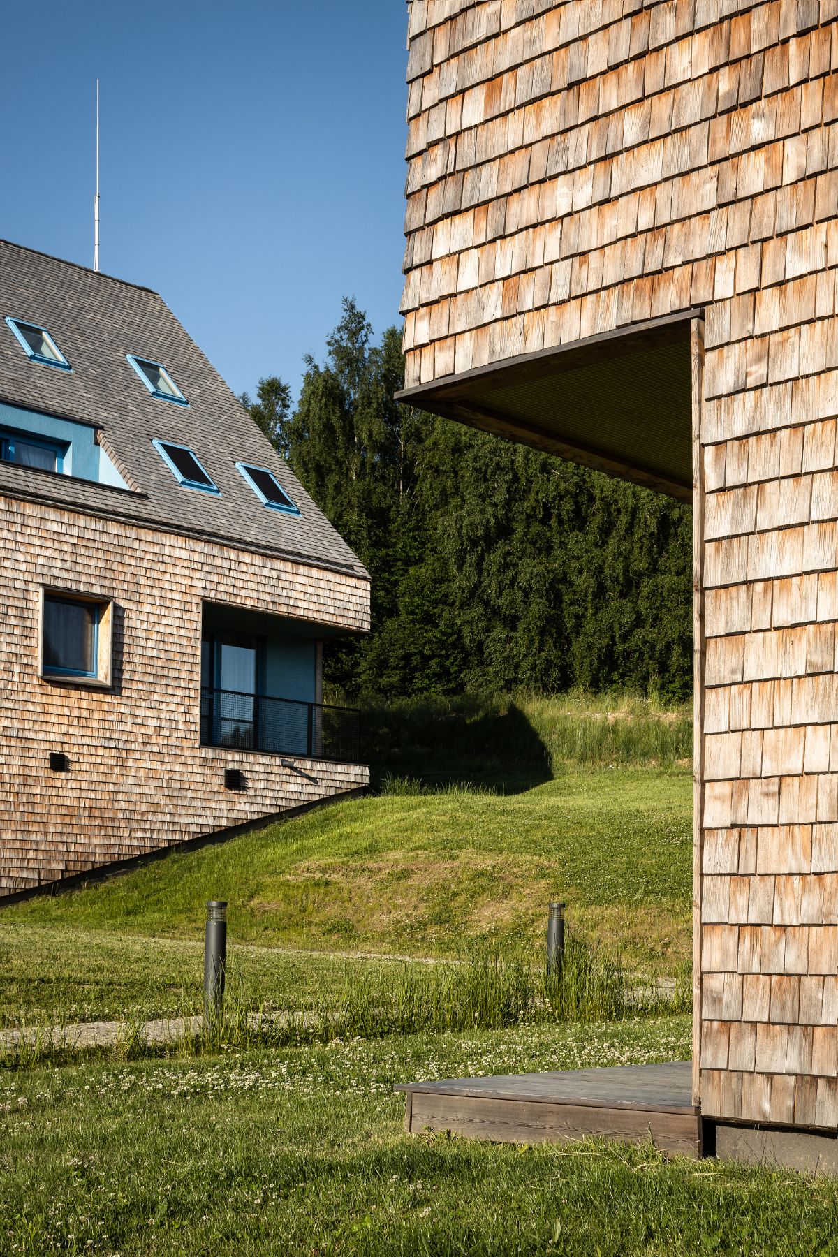 The balcony has a wooden deck facing the other house.