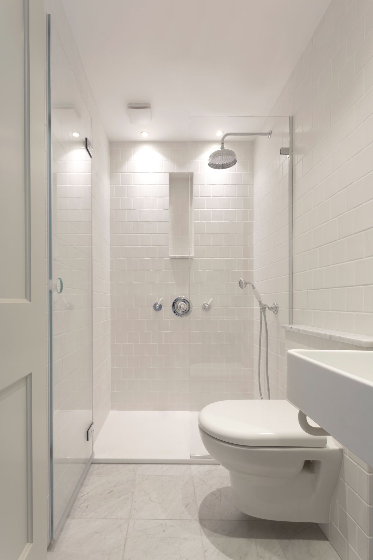 The guest bathroom features a floating toilet and a small shower room.