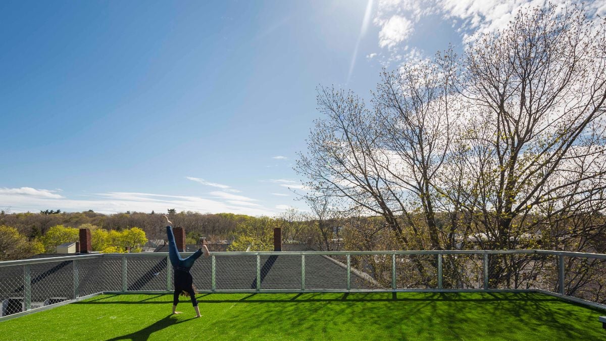 A photograph taken from the top of the unit, showcasing a grass-covered area and a screen that serves as a fence.
