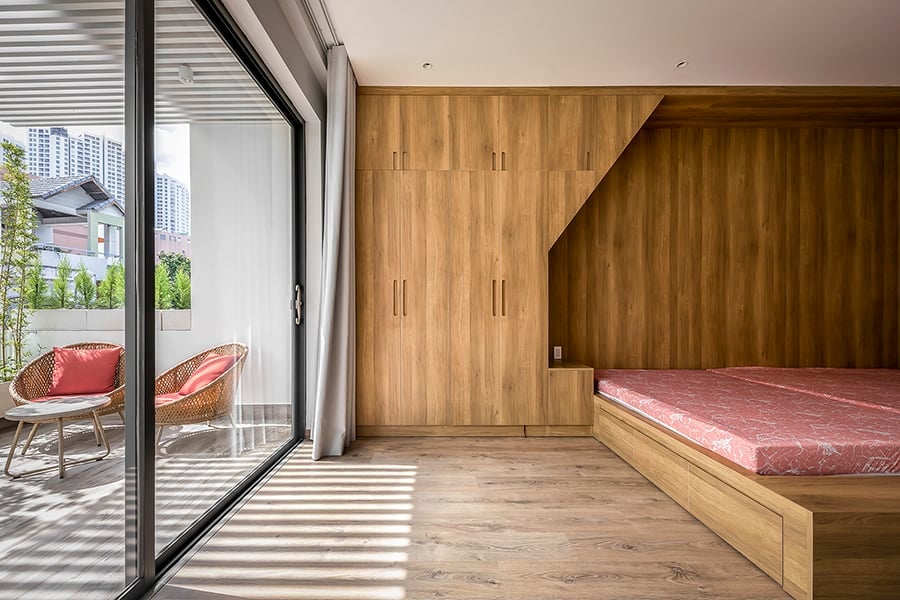The primary suite has also a bespoke bed integrated with a built-in wardrobe. It includes a private porch accessible via oversized glass doors.