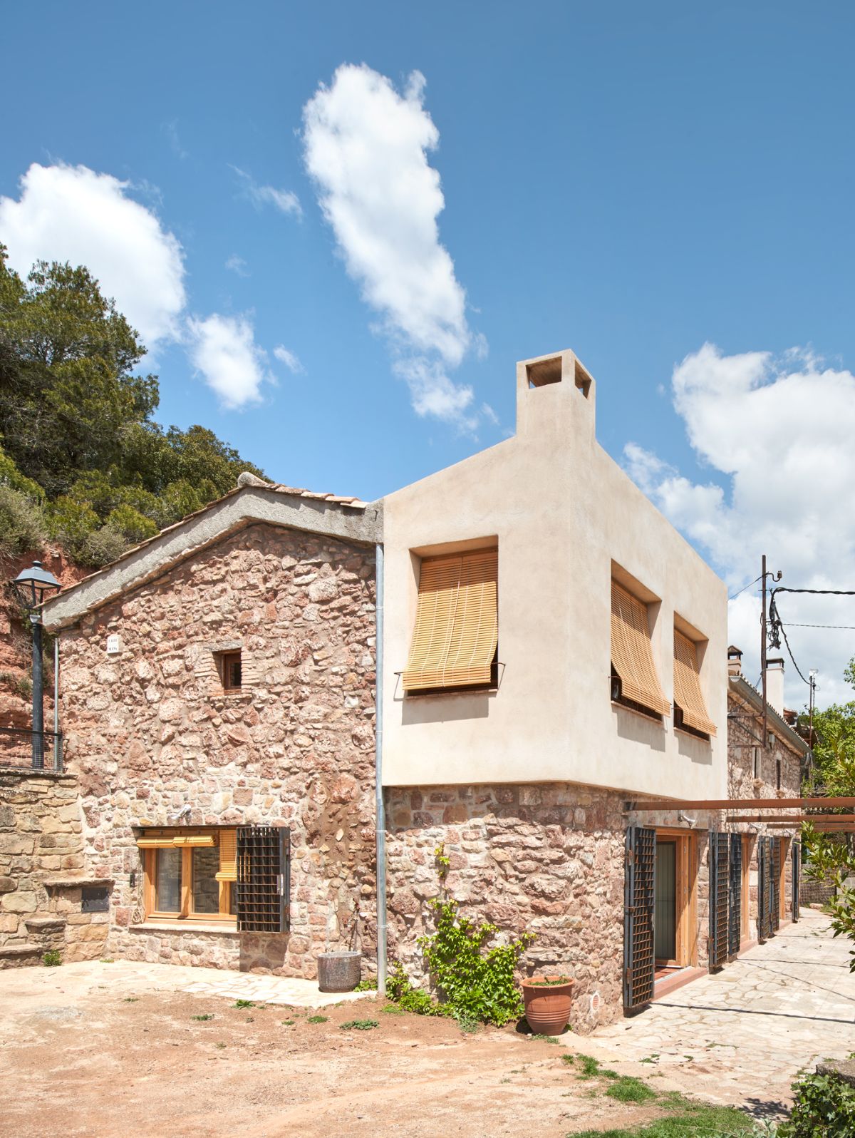 A part of the house has a concrete finish and the windows have rolling blinds.