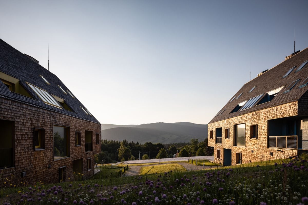 The houses face each other and are surrounded by beautiful flowers.