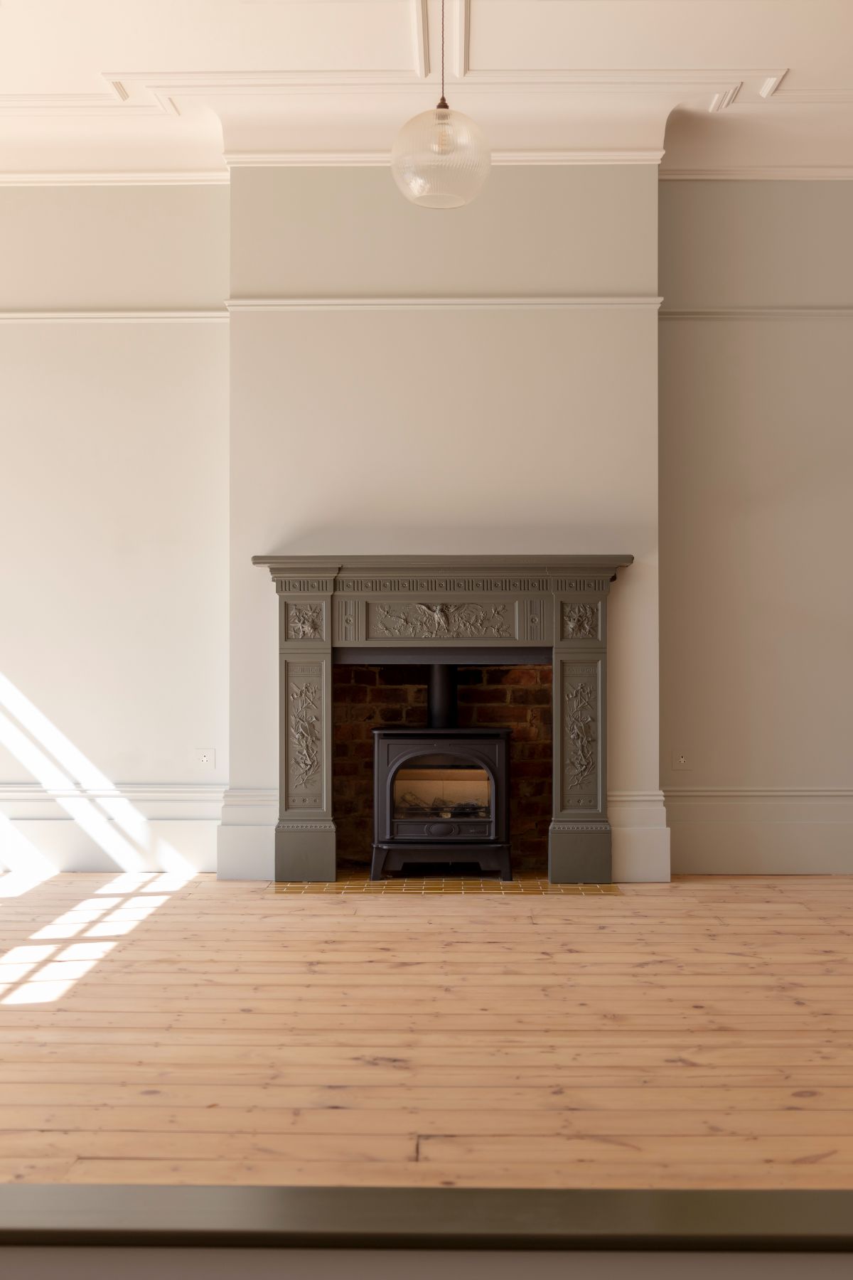 The living has a classic wood-burning fireplace and a wooden floor.