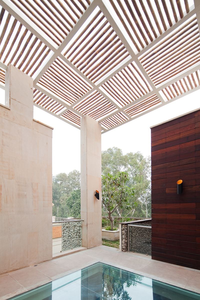 Through this jenga-like arrangement, the volumes appear to float between a pergola on the roof and a pool at the entrance.