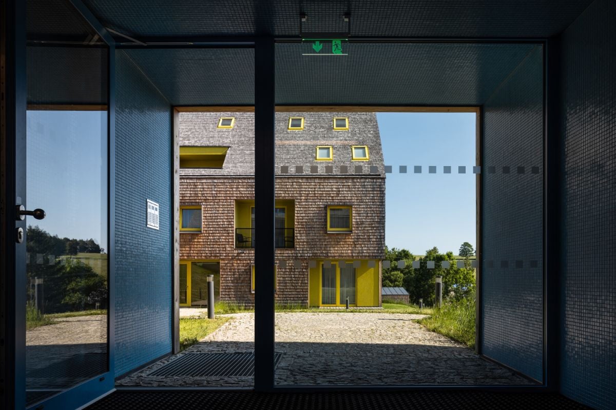 The entrance has a glass door overlooking the other house.