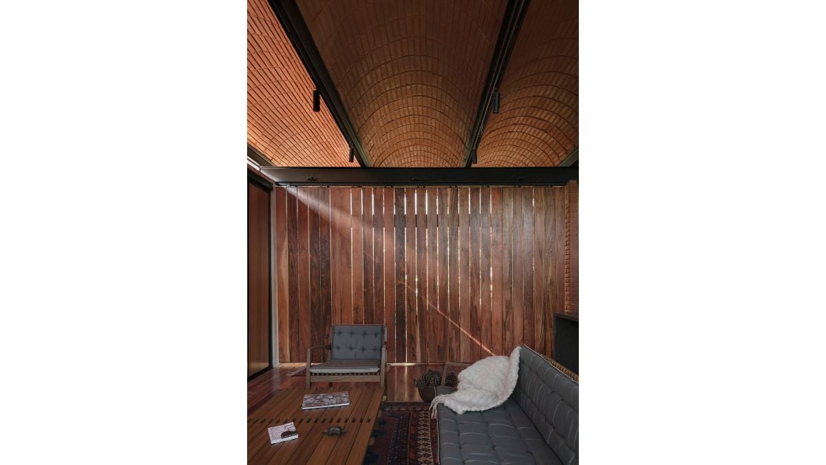 The gray couch complements the other elements in the room, such as the wood materials used in every corner.