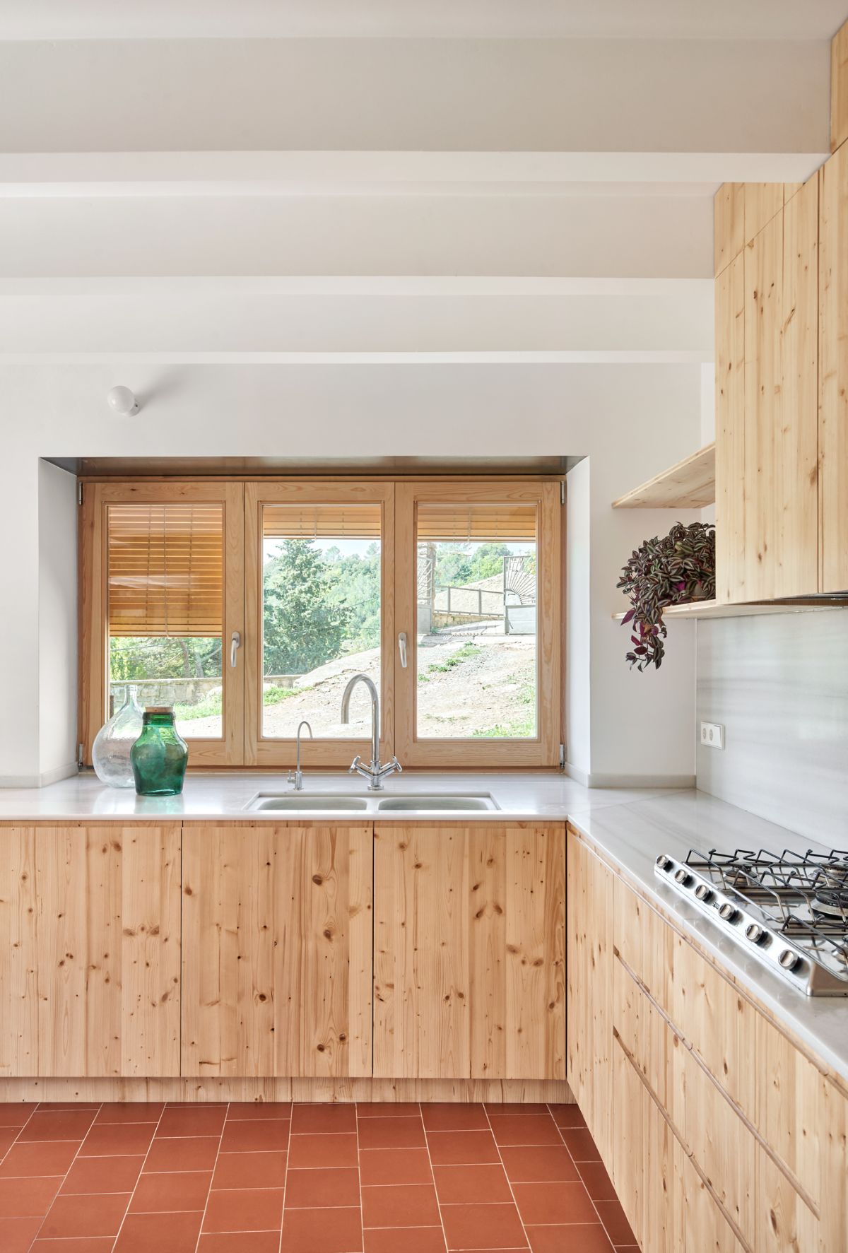The kitchen has a granite countertop and the wooden cabinet blends well with the white paint.