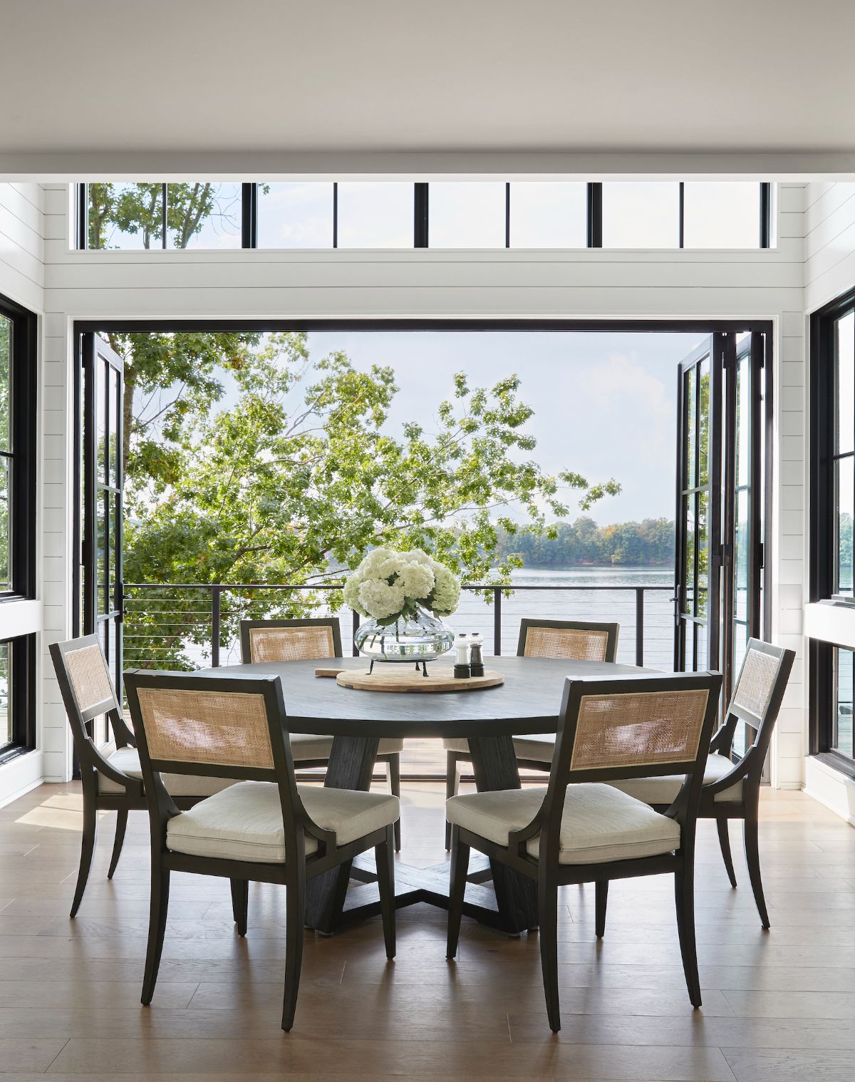 The dining area has access to the terrace through a glass door that overlooks the lake.