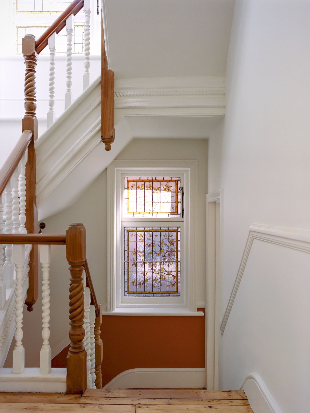 The wooden staircase with a classic design leads to the upper floors of the house.