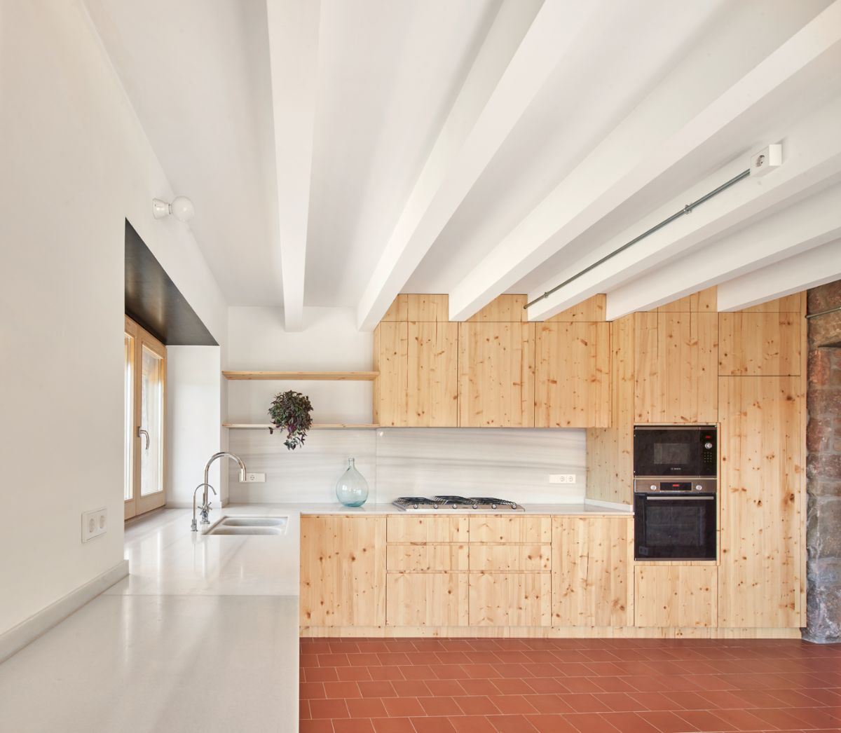 This view of the kitchen showcases the L-shape layout giving enough space to the room.