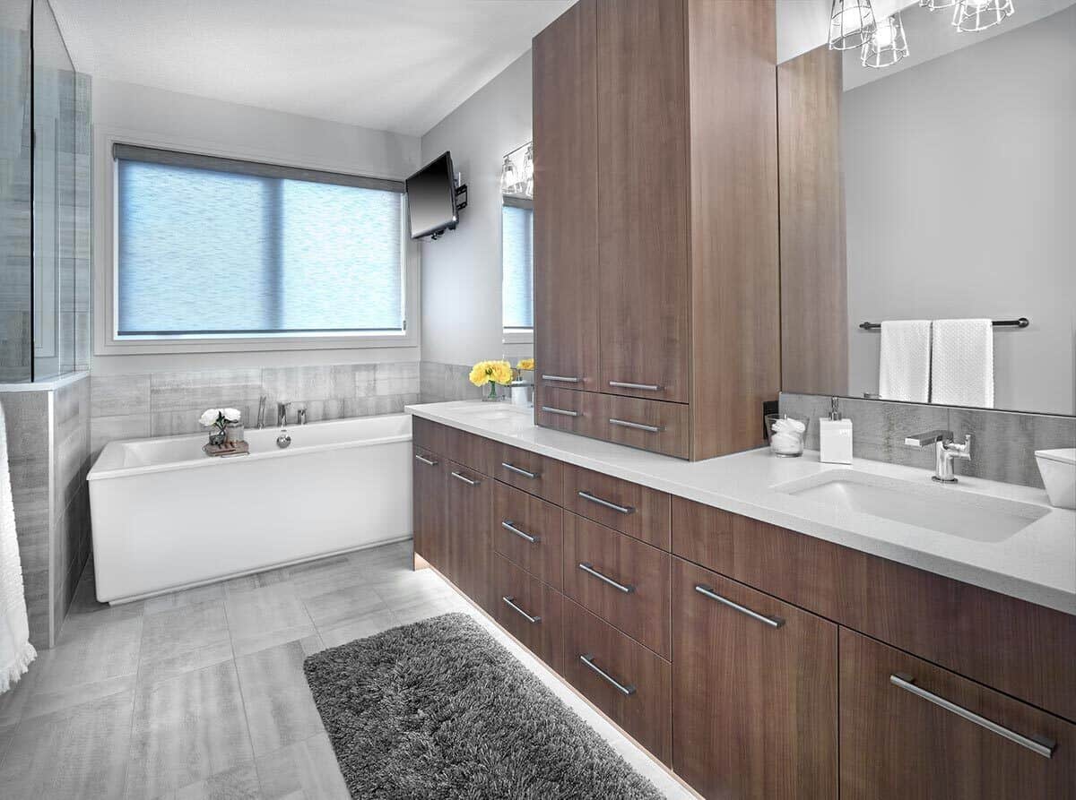 The primary bathroom is equipped with a dual sink vanity, a walk-in shower, a deep soaking tub, and a wall-mounted TV.