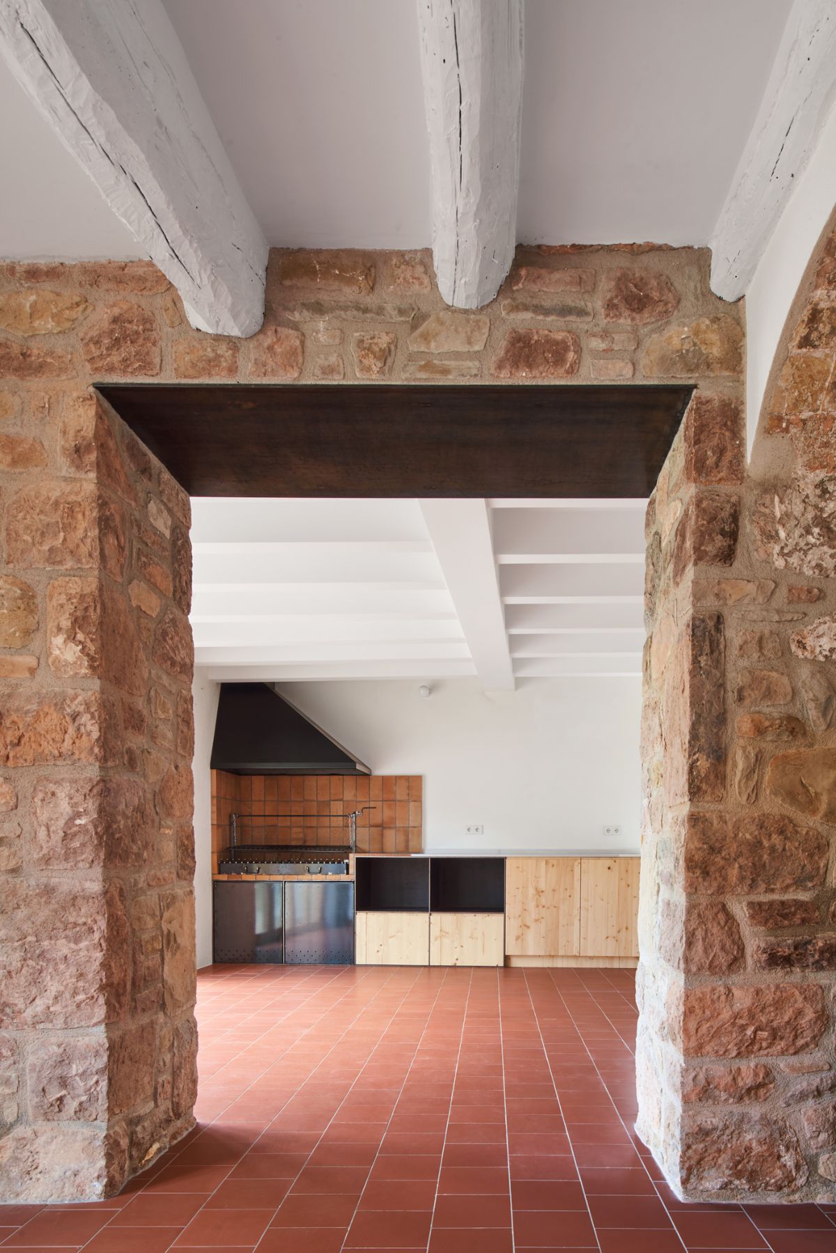 The house has an wooden ceiling and a stone wall that serves as the foundation of the house.