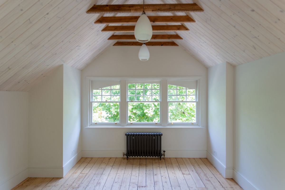 The simply designed front bedroom, where the wooden ceiling blends well with the white color, creates a cool atmosphere.