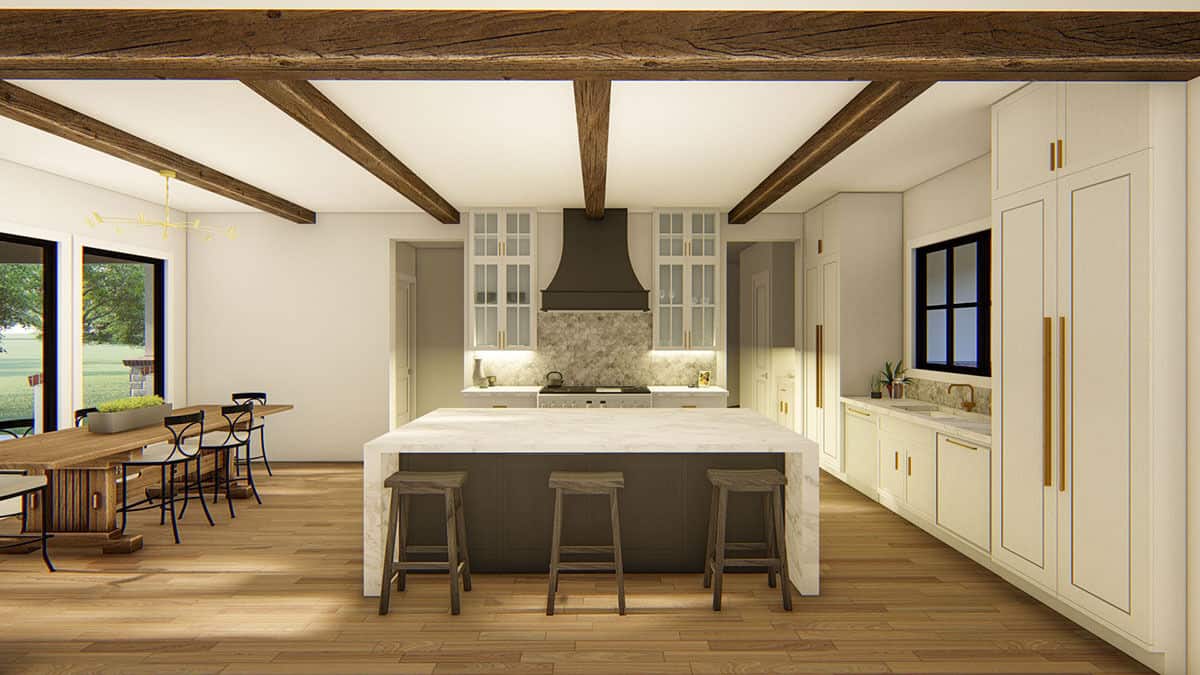 The kitchen features a waterfall island and pristine white cabinets accentuated with brass hardware.
