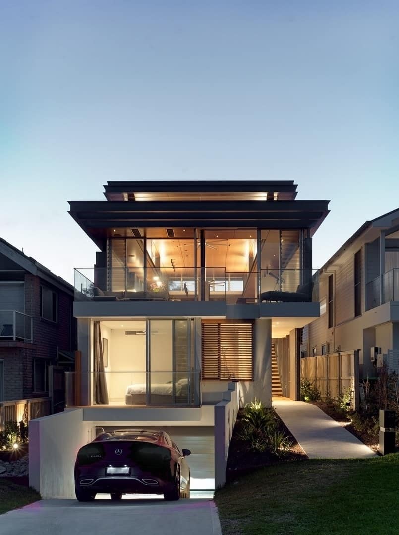 Home's facade showcasing full-height glazing, layered roofs, and an underground garage.