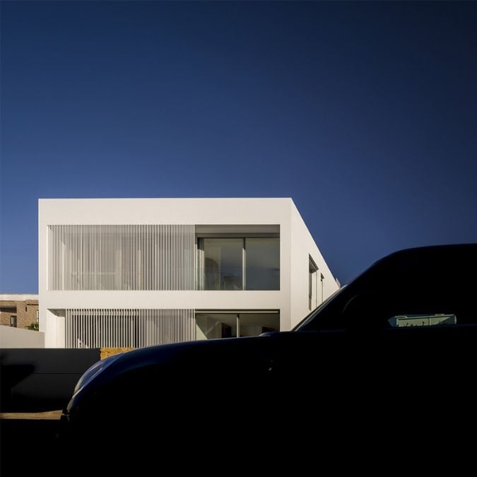 A distant exterior photograph of Villa Salam residential property, featuring a partial glimpse of a parked vehicle adjacent to the house.