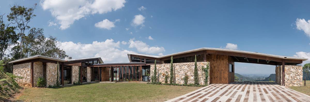The sprawling house is clad in wood and beautiful stonework. Sleek rooflines add character to the house.