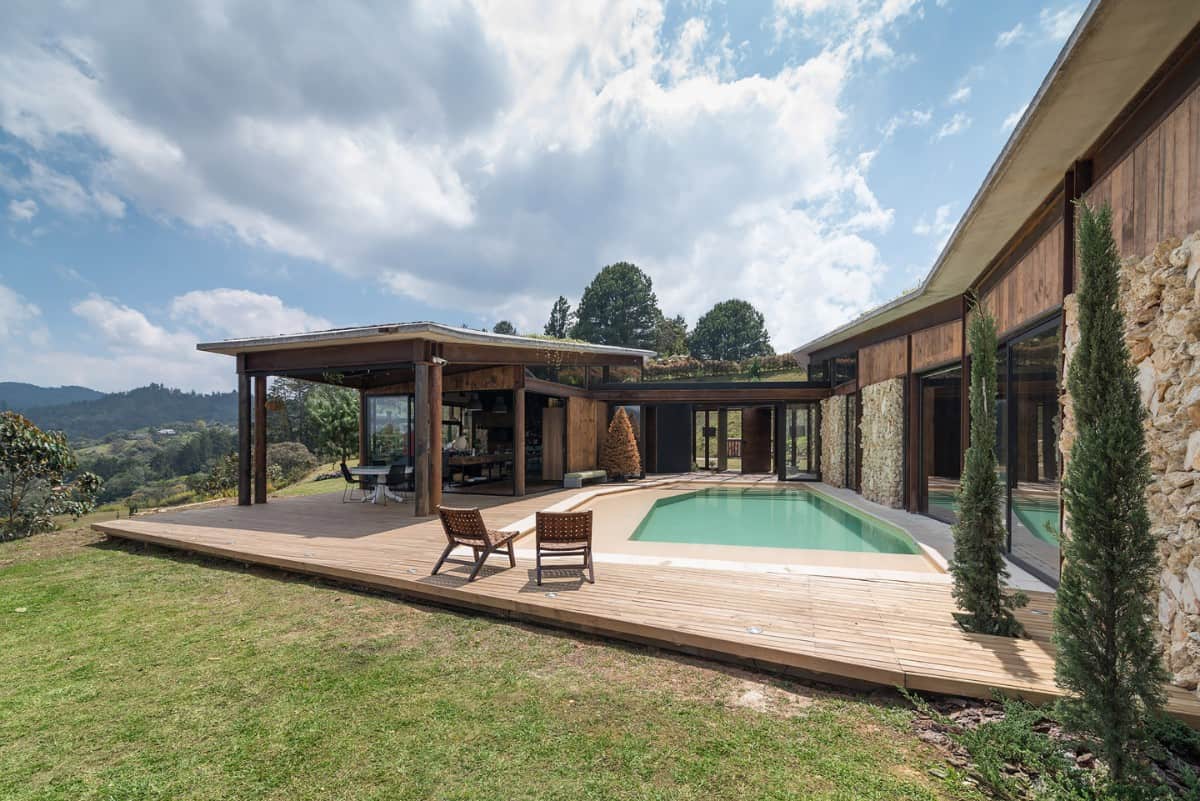 The house features a pool deck and a covered lanai supported by round timber posts.