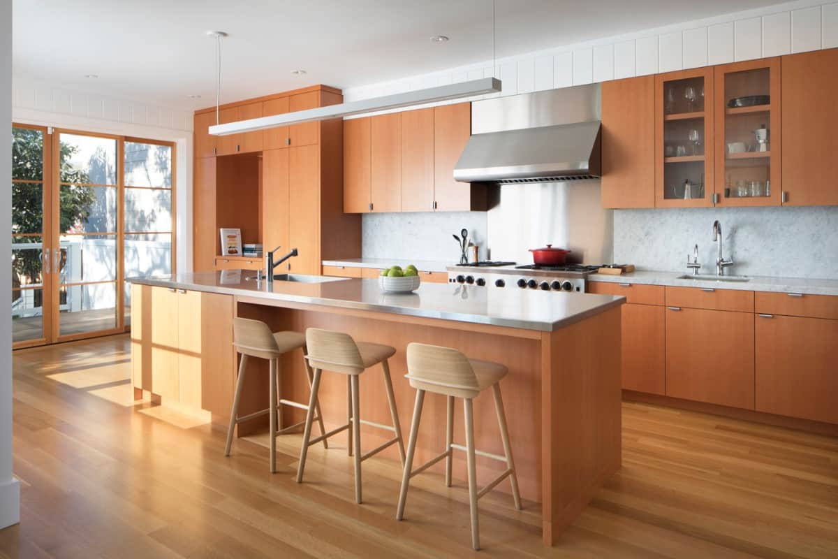 The kitchen's wooden cabinetry seamlessly blends in with the hardwood flooring.