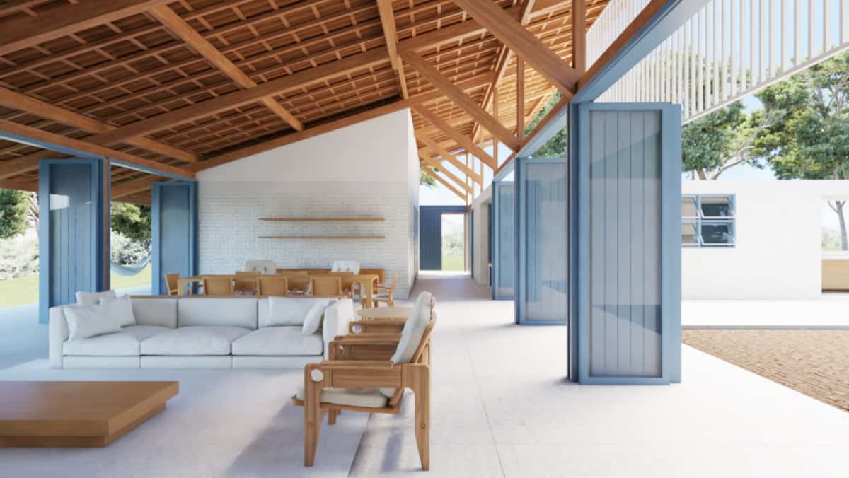The open living space is furnished with wooden chairs, matching tables, and a gray sectional sofa.