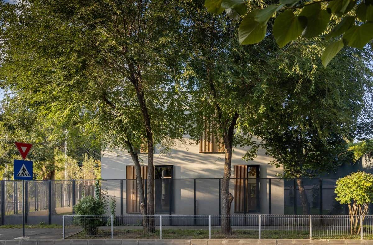 View of the house from the street surrounded by iron and metal fences.