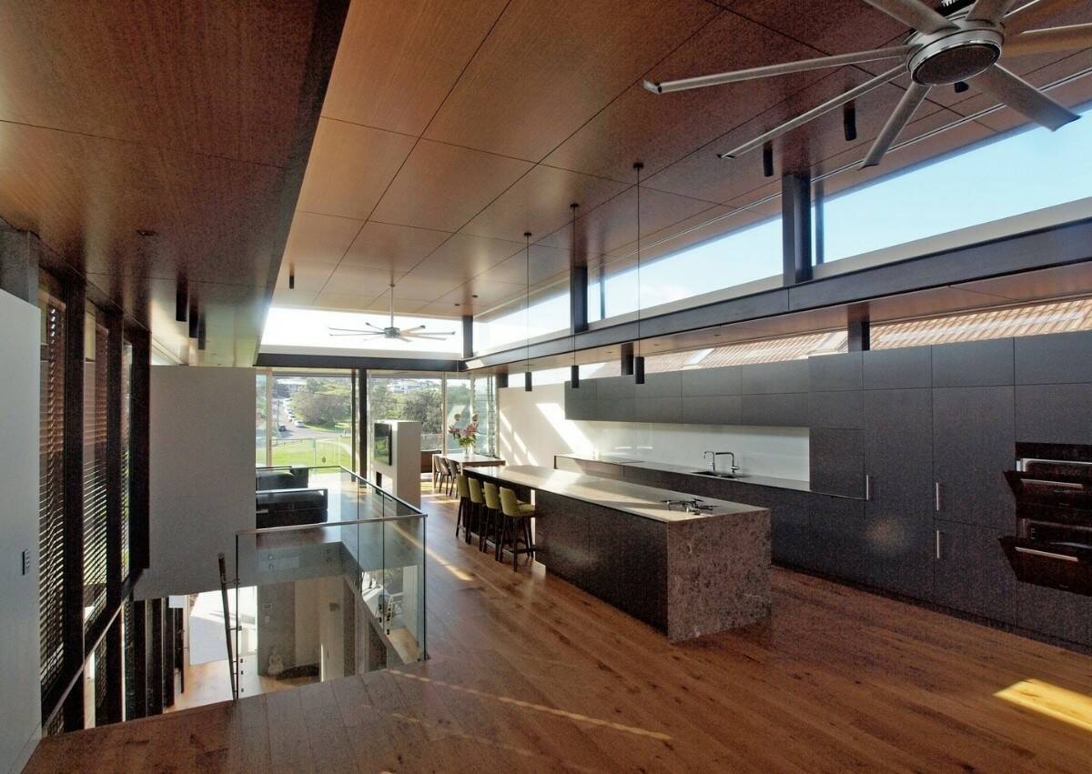 The kitchen features sleek cabinets and an elongated island with bar seating.