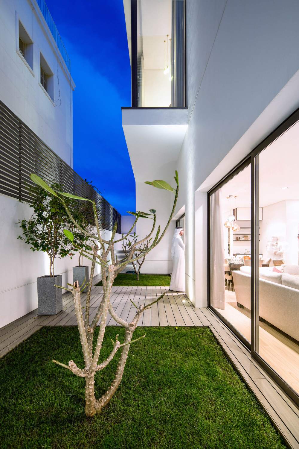 The ground floor accommodates the family's social areas and is illuminated by a private garden through expansive sliding windows.