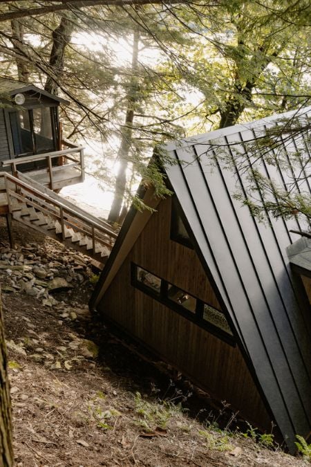 An exterior view of the rear of the house, showcasing the staircase leading to the outdoor room area.
