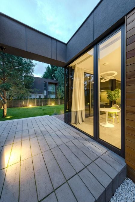 An exterior view capturing a full-height glass window through which the interior of the kitchen is visible.