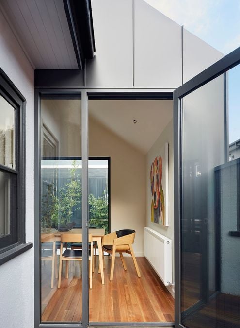 The provided photograph, captured from the outside, features an open door and offers a glimpse of the interior of the dining area.