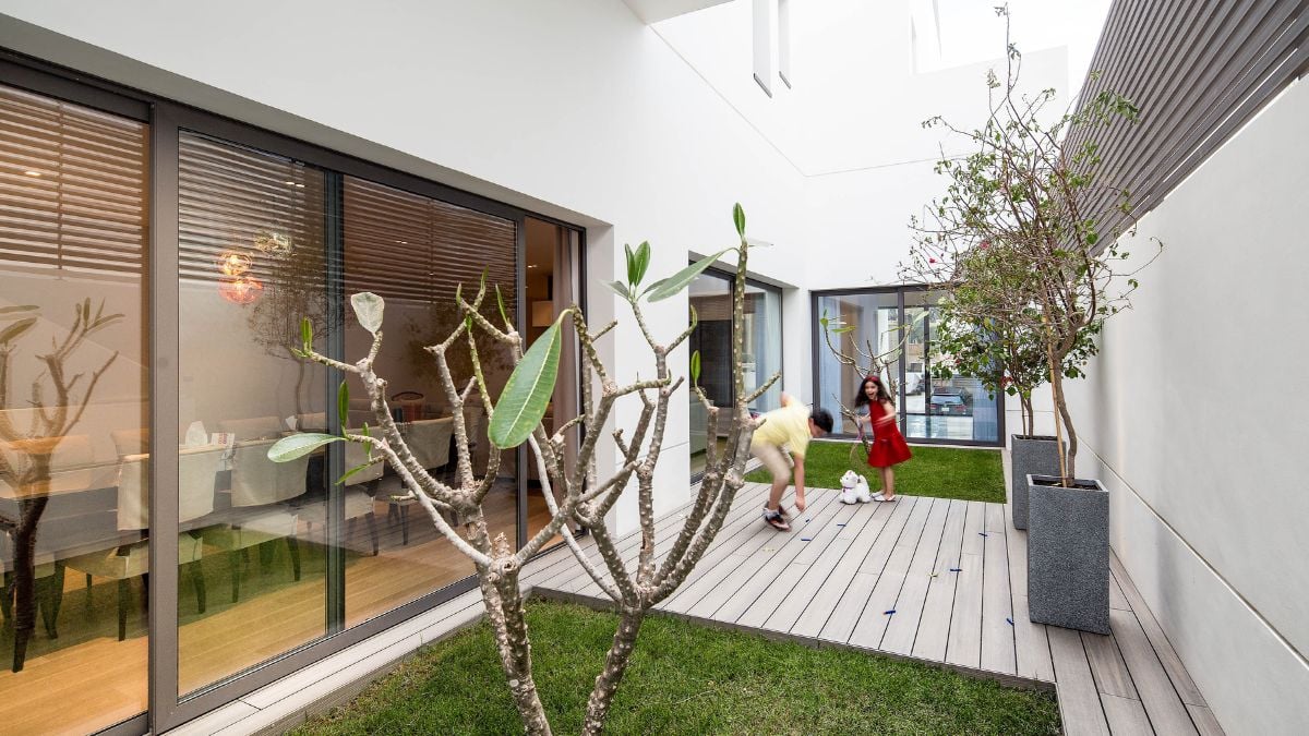 The ground floor accommodates the family's social areas and is illuminated by a private garden through expansive sliding windows.