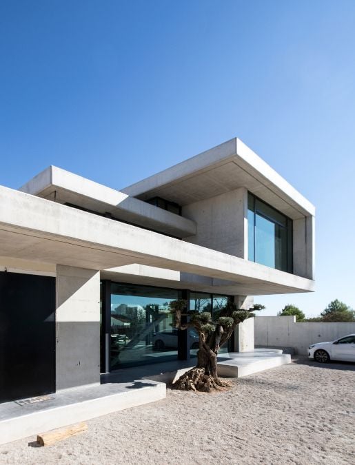 Another exterior shot that highlights the prominent use of exposed concrete in a significant portion of the building's structure, complemented by large windows that enhance the overall design aesthetic.