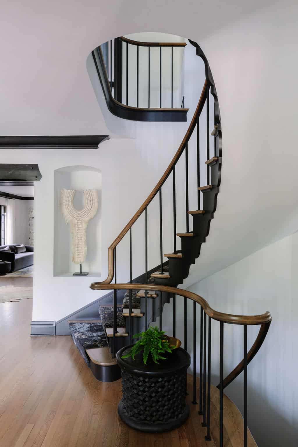 A spiral staircase with wrought iron spindles adds visual interest inside.