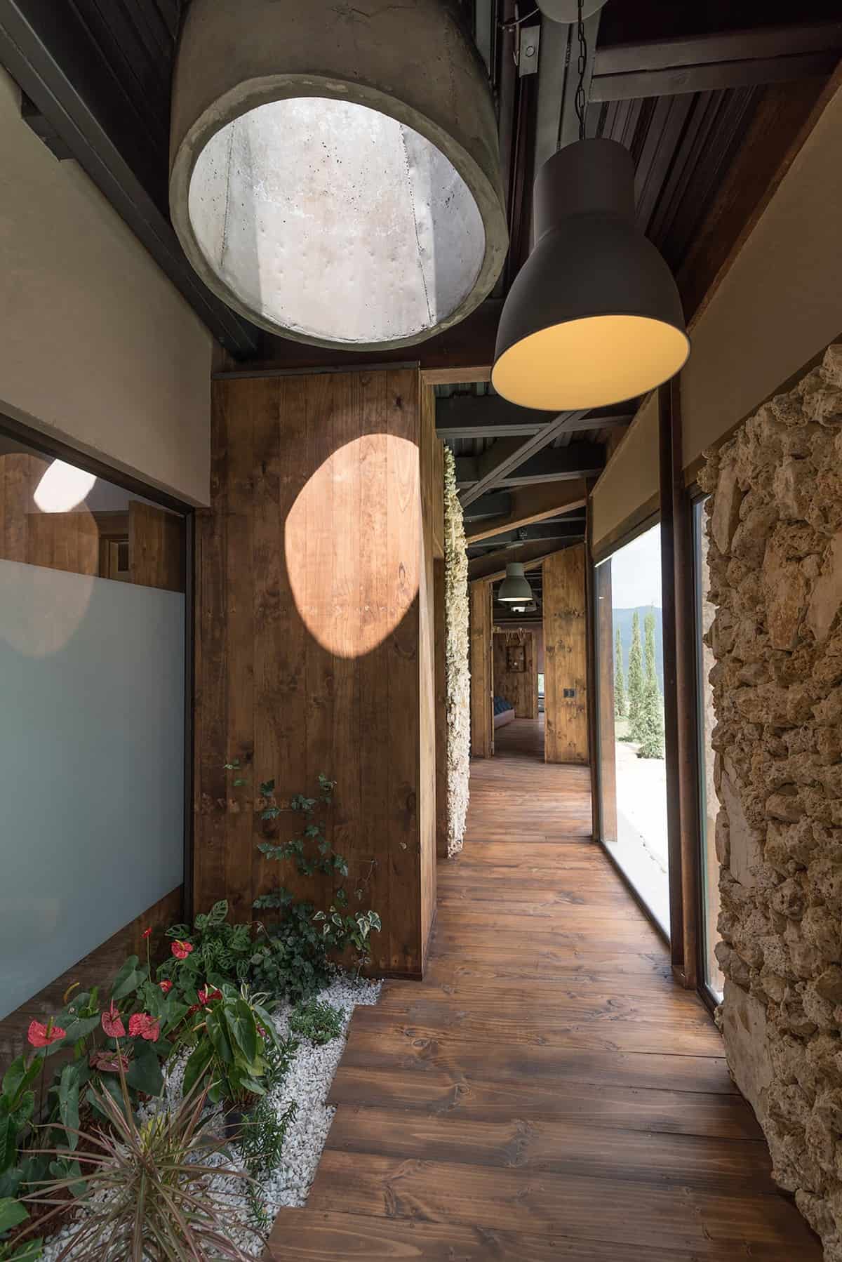 Oversized pendants illuminate this hallway adorned with lovely plants.