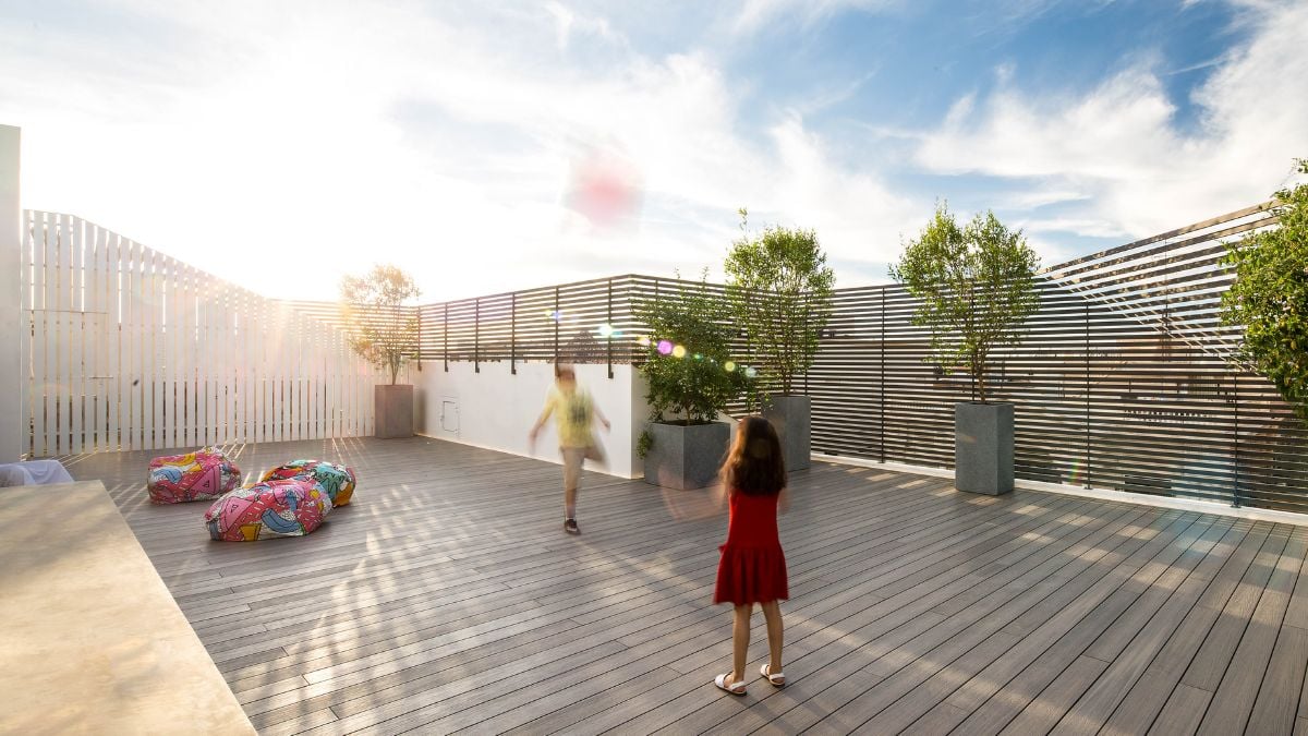 A spacious wooden deck covered with horizontal grilled fence.