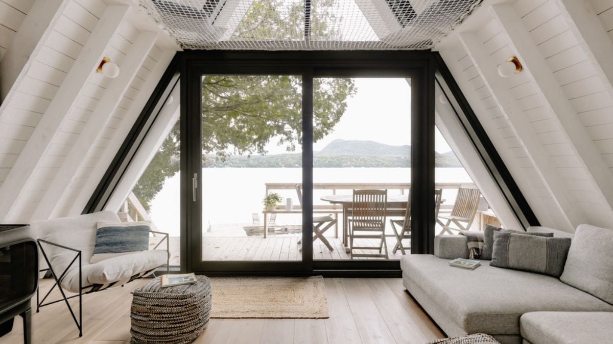 A photograph taken inside the house, showcasing the exterior view through the sliding glass doors and walls.