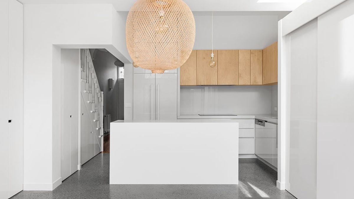 The photograph captures the minimalist interior design of the kitchen, from a certain perspective viewpoint.