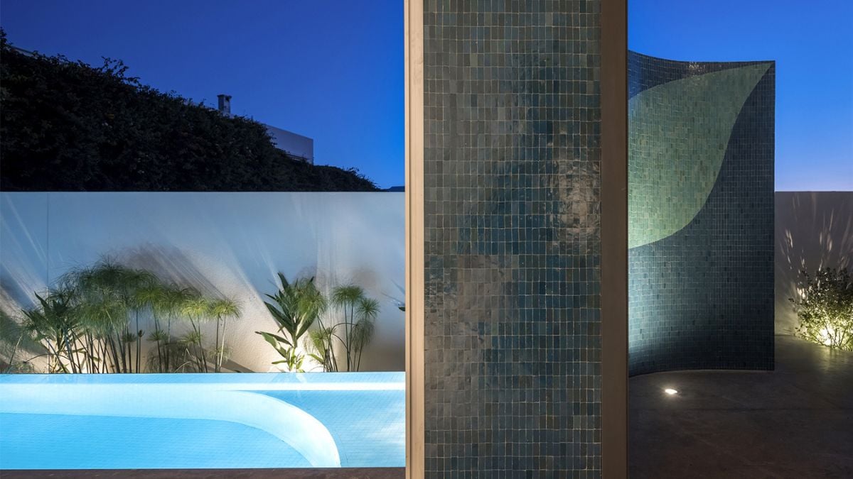 The photograph emphasizes the functionality of the wall as a cover for the pool area, protecting it from the elements while also adding to the overall aesthetic of the space.